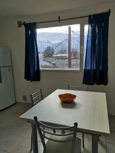 a table with a bowl on it in a kitchen with a window at Departamento amplio y luminoso in Esquel
