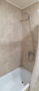 a bathroom with a shower with a white tub at Departamento amplio y luminoso in Esquel
