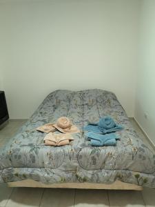 a bed with three towels on top of it at Departamento amplio y luminoso in Esquel