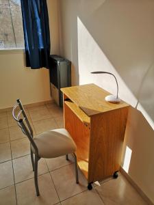 a desk and a chair with a lamp on it at Departamento amplio y luminoso in Esquel