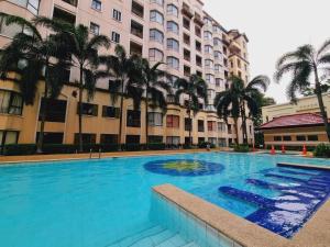 ein großer Pool mit Palmen vor den Gebäuden in der Unterkunft Newport's STAR in Manila
