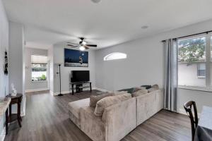 a living room with a couch and a tv at Elegant Comfort - Newly Updated 3BR with Cozy Master Suite - Pet Friendly in Tarpon Springs