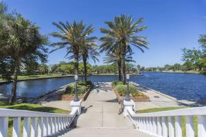 a woman walking down a walkway in front of a lake at Elegant Comfort - Newly Updated 3BR with Cozy Master Suite - Pet Friendly in Tarpon Springs