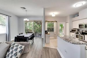 a kitchen and living room with a table and a couch at Elegant Comfort - Newly Updated 3BR with Cozy Master Suite - Pet Friendly in Tarpon Springs