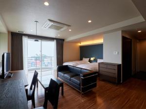 a hotel room with a bed and a couch at Chateraise Lodge Atami in Atami