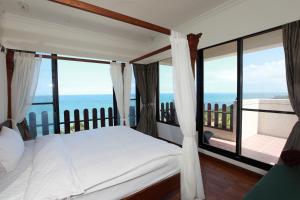 鹽寮村的住宿－海明蔚，一间卧室设有一张床,享有海景