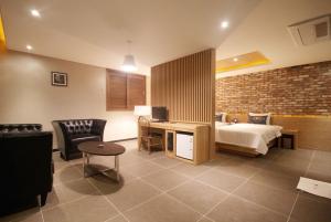 Hotel Able في تشانغوون: غرفة نوم بسرير ومكتب في غرفة