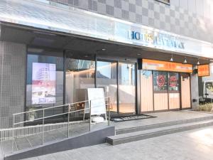 een winkel voor een gebouw met glazen ramen bij HOTEL LiVEMAX Chiba-Ekimae in Chiba