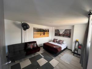 a bedroom with a bed and a couch and posters at Hermoso apartamento 501 Ibagué in Ibagué