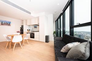 Una sala de estar con un sofá negro y una mesa. en Fantastic Urban Oasis, en Melbourne 19 fotos más