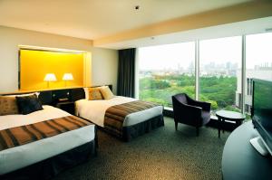 a hotel room with two beds and a large window at Hotel New Otani Tokyo The Main in Tokyo