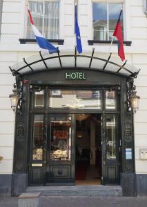 un hotel con banderas en la parte delantera de un edificio en De Bronzen Koets, en Nijmegen