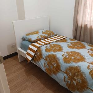 a small bedroom with a bed with a bedspread with palm trees at Infina Towers Affordable Staycation 8 units-2 BR in Manila