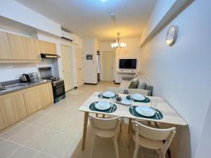 a kitchen and living room with a table and chairs at Infina Towers Affordable Staycation 8 units-2 BR in Manila