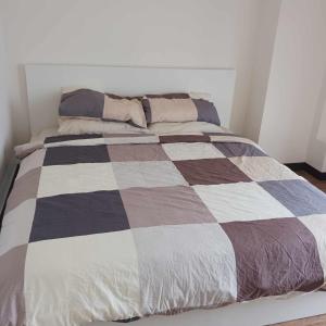 a bed with a checkered blanket on top of it at Infina Towers Affordable Staycation 8 units-2 BR in Manila