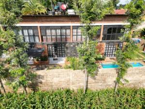 uma casa com uma parede de tijolos e árvores em Jabulani Private Villas em Arusha