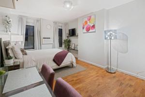 a white bedroom with a bed and a living room at Studio Haven in Times Square & Nearby Restaurants in New York