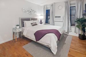 a bedroom with a large bed with a purple blanket at Studio Haven in Times Square & Nearby Restaurants in New York