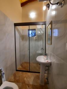 a bathroom with a shower and a sink and a toilet at Resort Sport in Independencia