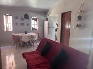 a living room with a red couch and a table at Canto da Gaivota Lençóis Maranhenses in Santo Amaro