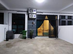 - un salon avec une porte s'ouvrant sur une pièce dans l'établissement D'has Homestay Kuantan, à Kampong Baharu