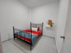 - une chambre blanche avec un lit rouge dans l'établissement D'has Homestay Kuantan, à Kampong Baharu