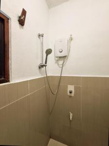 een douche in een badkamer met een douchekop bij Flo Island Home in General Luna