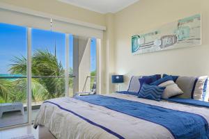 ein Schlafzimmer mit einem großen Bett und einem großen Fenster in der Unterkunft LUXURIOUS APARTMENT IN LEVENT FRONT EAGLE BEACH in Palm-Eagle Beach