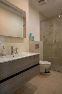 een badkamer met een wastafel, een toilet en een douche bij LUXURIOUS APARTMENT IN LEVENT FRONT EAGLE BEACH in Palm-Eagle Beach