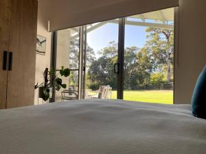 ein Schlafzimmer mit einem Bett und einem großen Fenster in der Unterkunft Isle of Kilcarnup in Margaret River Town