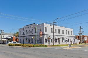 a white building on the corner of a street at Albion Motel Finley in Finley