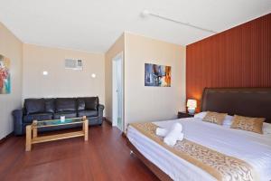- une chambre avec un grand lit et un canapé dans l'établissement Albion Motel Finley - Best Rates in Town, Short & Extended Stays, à Finley