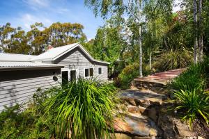 a house with a retaining wall next to a house at Annecy House in Daylesford