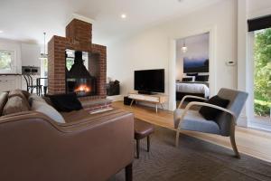 a living room with a couch and a fireplace at Annecy House in Daylesford