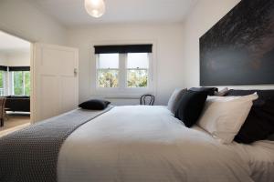 a bedroom with a large bed with pillows on it at Annecy House in Daylesford