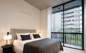 a bedroom with a large bed and a large window at Alfred & Turner Apartments, Luxury 2 Bedroom Condos in heart of the Valley in Brisbane