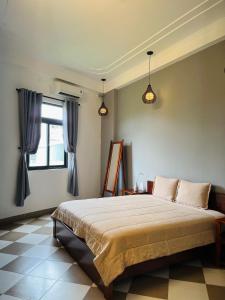 ein Schlafzimmer mit einem großen Bett und einem Fenster in der Unterkunft Queenie House in Cần Thơ