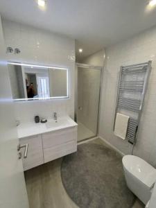 a bathroom with a sink and a toilet and a mirror at Modern 1 Bedroom City Center Aveiro Apartment in Aveiro