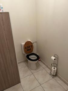 łazienka z toaletą z napisem na siedzeniu w obiekcie Charmant appartement la Roche sur Yon w mieście La Roche-sur-Yon