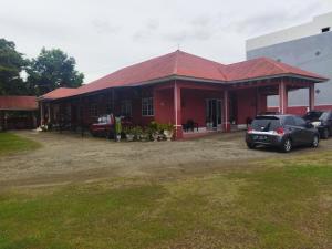 czerwony budynek z samochodami zaparkowanymi przed nim w obiekcie OYO 92775 Wisma Phinisi Syariah 