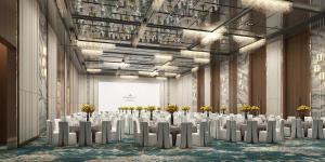 - une salle de banquet avec des tables blanches, des chaises et des fleurs dans l'établissement Dorsett Kai Tak, à Hong Kong