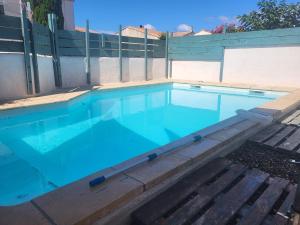 a swimming pool with blue water in front of a fence at Maison de ana in Arles