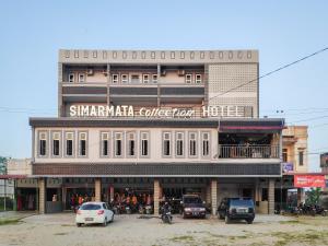 un edificio con coches estacionados frente a él en RedDoorz at Perdagangan Simalungun, en Perdagangan-tomuon