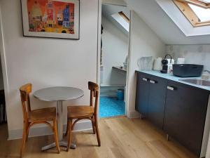 a kitchen with a table and two chairs and a sink at Au trente-neuf in Nevers