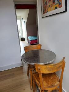 a table and chairs in a room with a bedroom at Au trente-neuf in Nevers +2 photos