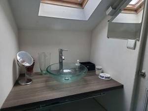 a bathroom with a glass bowl sink on a wooden counter at Au trente-neuf in Nevers