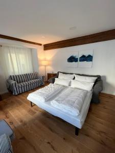 a bedroom with a white bed and a couch at Altstadtjuwel in Gmunden am Traunsee in Gmunden