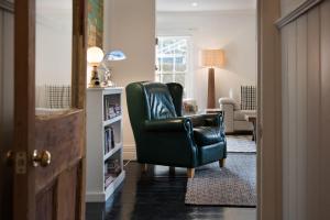 een woonkamer met een zwarte leren stoel in een kamer bij Aysgarth in Daylesford