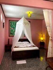 a bedroom with a bed with a mosquito net at Homestay Sente in Munduk