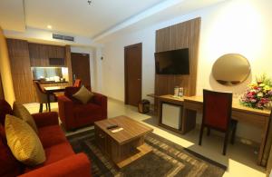梭羅的住宿－Lorin Dwangsa Solo Hotel，客厅配有红色的沙发和桌子